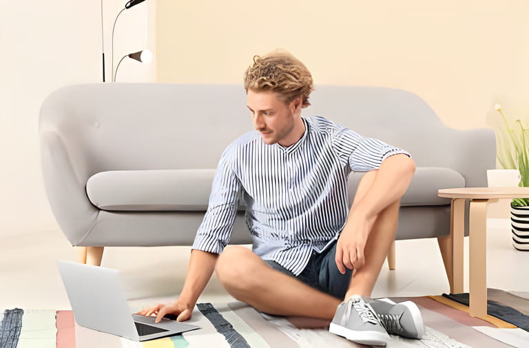 Young man with laptop sitting on floor at home Young man with laptop sitting on floor at home