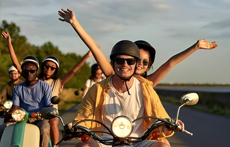 Smiling couple of friends enjoying riding vintage scooters on vacation outside the city. Fun, leisure activity, summertime, transportation concept