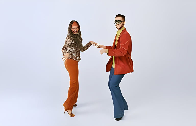 Old school party. Stylish young man and woman in colorful retro outfits dancing disco dance isolated over grey studio background. 70s fashion, hobby, creativity, hippie lifestyle, American culture