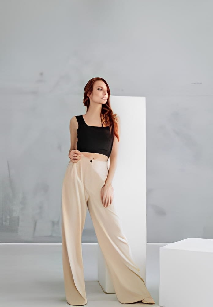 an attractive young red-haired woman in a black tank top and wide white stylish trousers. slim female model in pants, casual style an attractive young red-haired woman in a black tank top and wide white stylish trousers. slim female model in pants, casual style