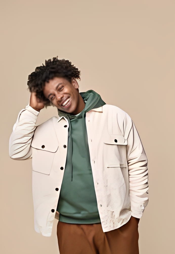 Happy young African American gen z guy isolated on beige background. Smiling hipster ethnic teen student, cool curly ethnic generation z teenager fashion model standing laughing, vertical shot. Happy young African American gen z guy isolated on beige background. Smiling hipster ethnic teen student, cool curly ethnic generation z teenager fashion model standing laughing, vertical shot.