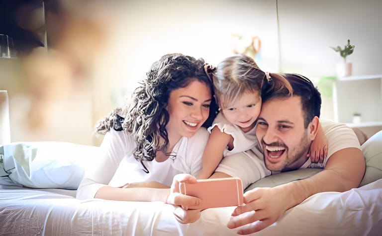 Happy young family takes a self portrait with smartphone. Happy young family takes a self portrait with smartphone.