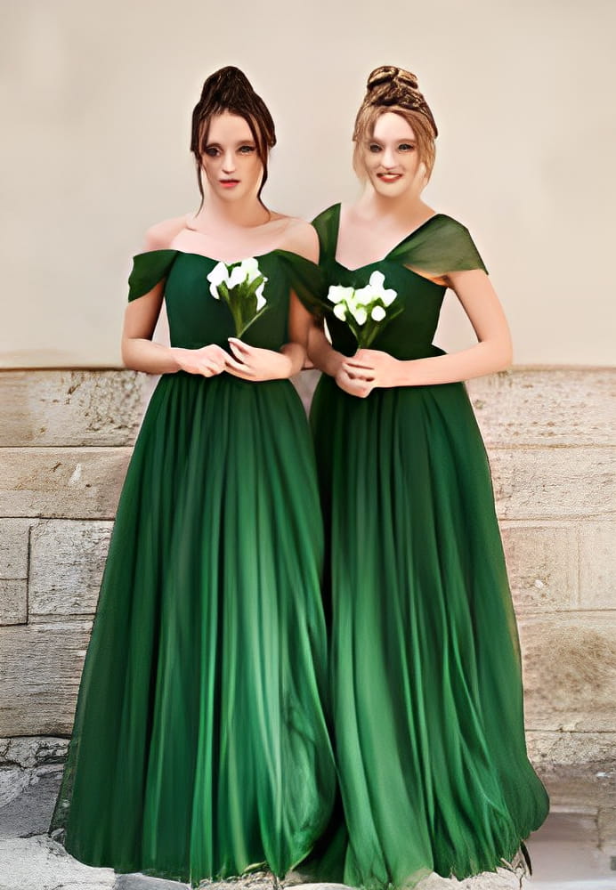 Two beautiful bridesmaids girls blonde and brunette ladies wearing elegant full length off-the-shoulder green chiffon bridesmaid dress and holding flower bouquets. 
