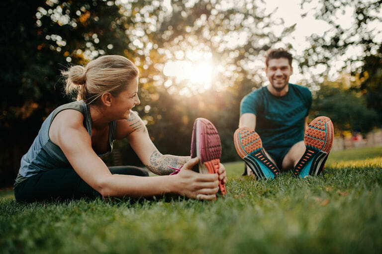Young couple doing stretches in the park