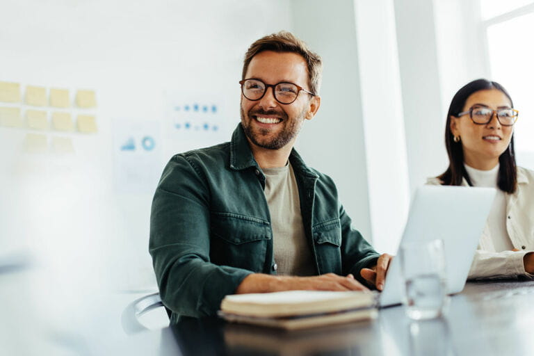 Happy business man listening to a discussion in the office