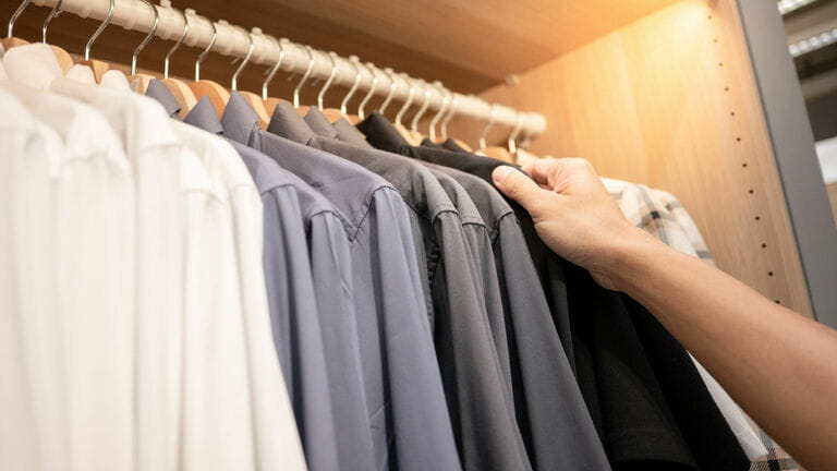 Male hand choosing shirt in wardrobe Male hand choosing shirt in wardrobe
