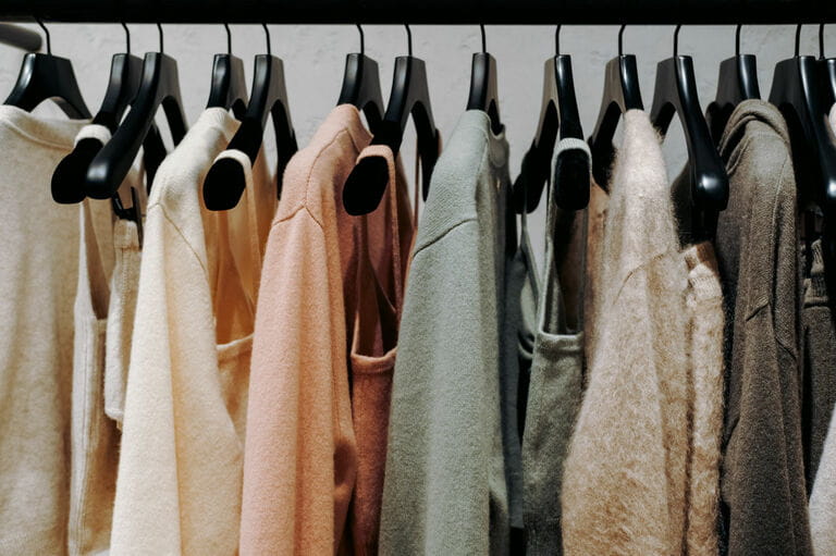 Clothes are neatly hung by color, systematization of clothes in closet. Shopping fashion sale background. colorful clothes on hangers. selective focus Clothes are neatly hung by color, systematization of clothes in closet. Shopping fashion sale background. colorful clothes on hangers. selective focus