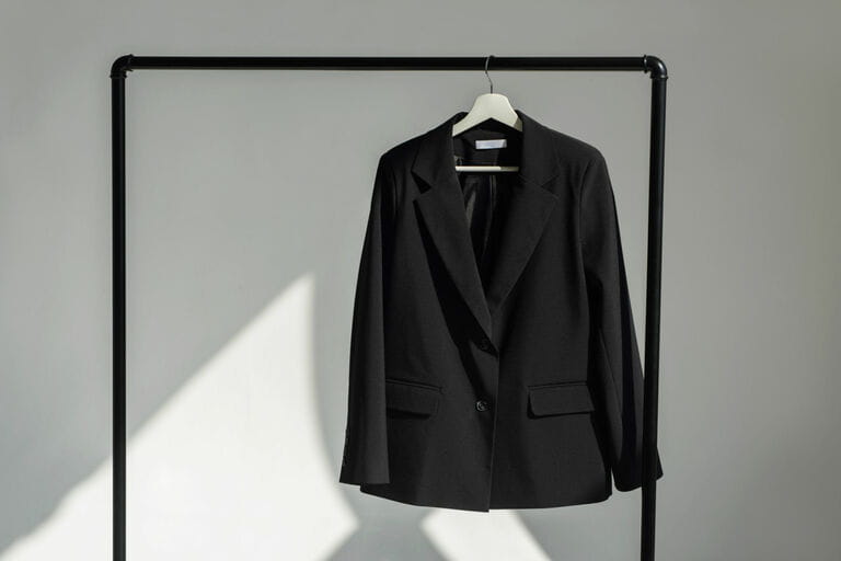 Classic black jacket hanging on the shoulder on a rail Classic black jacket hanging on the shoulder on a rail