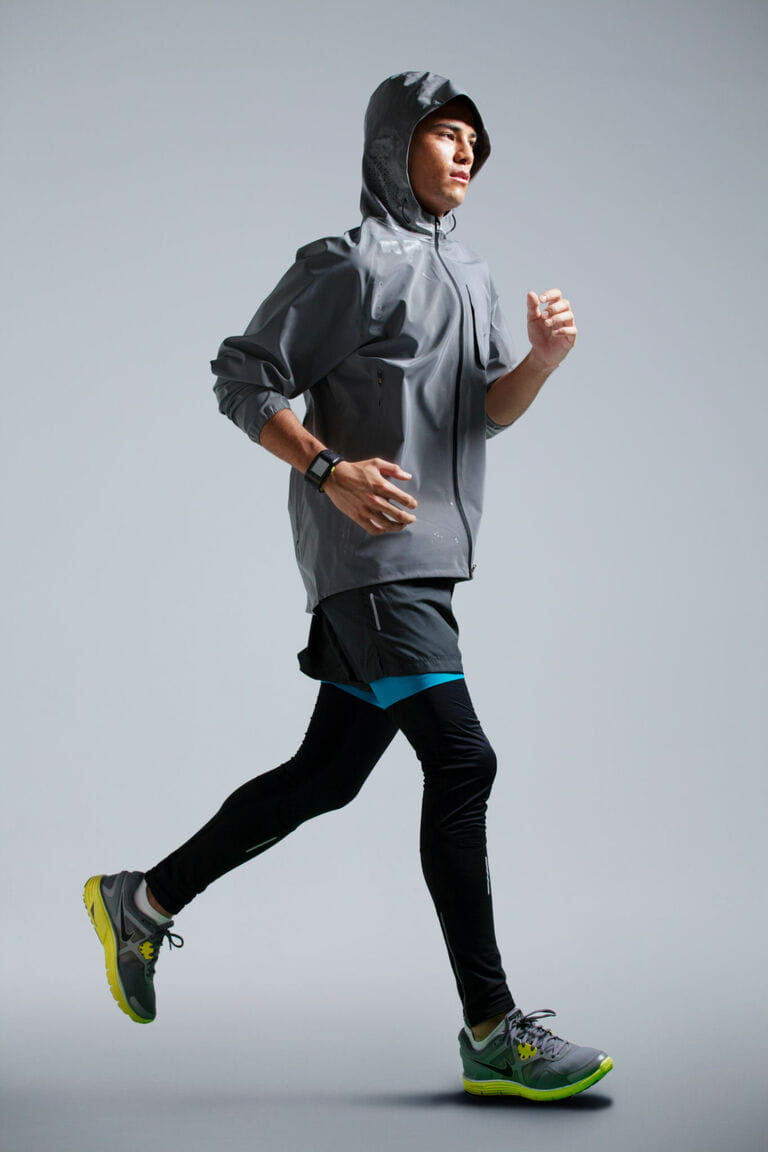 Man running on grey background wearing workout apparel