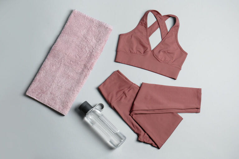 Sportswear, water bottle and towel on gray background, lying flat Sportswear, water bottle and towel on gray background, lying flat