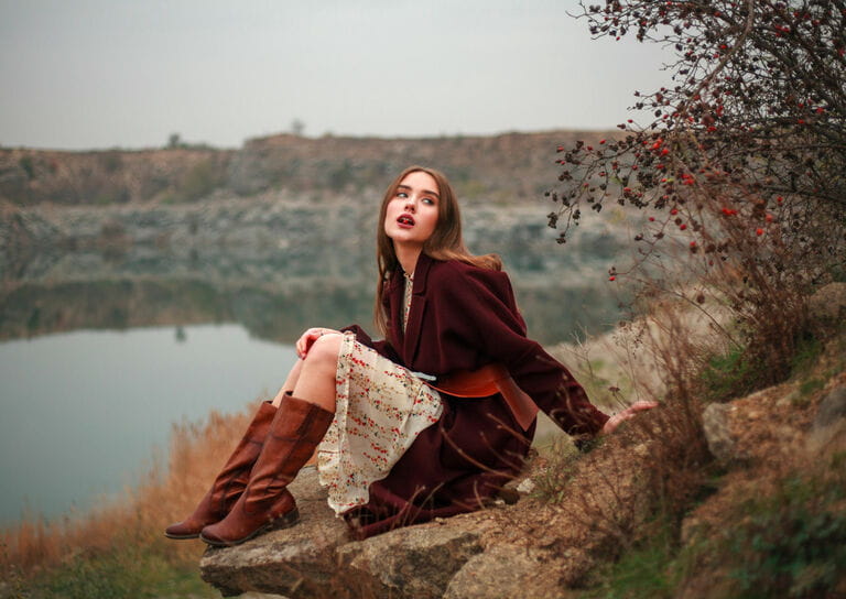 Young woman wearing ao dai and brown boots by the lake in the countryside in autumn Young woman wearing ao dai and brown boots by the lake in the countryside in autumn