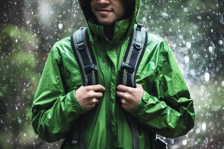 Young man hiking in the rain with waterproof jacket Young man hiking in the rain with waterproof jacket