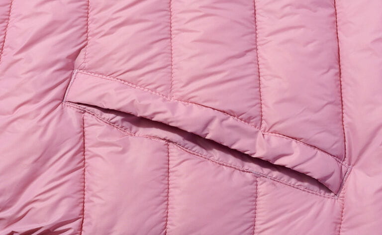 A piece of pink fabric with down filling and stitching, fabric for coats and jackets