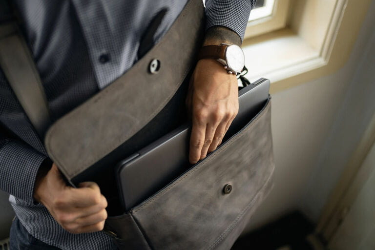 Close-up of unrecognizable businessman taking laptop out of briefcase